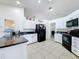 Well-lit kitchen with white cabinets, black appliances, and tile flooring, offering ample counter space at 1125 Almond Tree Cir, Orlando, FL 32835