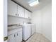 Functional laundry room featuring modern appliances, cabinet storage, and a built-in utility sink at 1125 Almond Tree Cir, Orlando, FL 32835