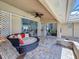 Cozy outdoor patio area with comfortable wicker seating, ceiling fan, and access to screened pool at 1125 Almond Tree Cir, Orlando, FL 32835
