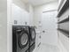 Bright laundry room featuring a modern washer/dryer, white cabinetry, and convenient shelving at 18623 Tunbridge St, Orlando, FL 32833
