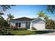 Charming single-story home with a two-car garage, complemented by a well-manicured lawn and lush landscaping at 21 Locust Ter, Ocala, FL 34472