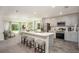 Modern kitchen featuring stainless steel appliances, gray cabinets, a breakfast bar with stools, and open view to the living area at 21 Locust Ter, Ocala, FL 34472
