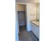 Bathroom vanity featuring white cabinets, countertop, mirror, and walk-in closet at 2525 Caper Ln # 205, Maitland, FL 32751
