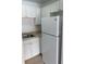 Bright kitchen featuring white cabinets and a full-size white refrigerator at 2525 Caper Ln # 205, Maitland, FL 32751