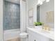 Contemporary bathroom featuring blue subway tile, shower-tub combo, and gold fixtures at 2752 Fiddle Leaf Lp Ave, Apopka, FL 32712