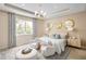 Luxurious main bedroom with a tray ceiling, chandelier, sitting area, and ample natural light at 2752 Fiddle Leaf Lp Ave, Apopka, FL 32712