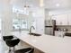 Bright kitchen features white cabinets, stainless steel appliances, an island with bar seating and lots of natural light at 3211 Sunrise Walk, Kissimmee, FL 34747