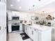 Well-lit kitchen with white cabinets, stainless steel appliances, a kitchen island, and an open design concept at 3211 Sunrise Walk, Kissimmee, FL 34747