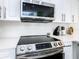 Modern kitchen with stainless steel appliances, including a range and microwave, and white cabinetry at 3211 Sunrise Walk, Kissimmee, FL 34747
