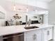Modern kitchen with stainless steel appliances, white cabinetry, stone countertops and island, and open to dining and living room at 3211 Sunrise Walk, Kissimmee, FL 34747