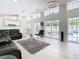 Spacious living room with high ceilings, large windows overlooking pool area, and stylish modern furniture at 3211 Sunrise Walk, Kissimmee, FL 34747