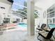 Covered pool area with ample seating and lounge chairs, providing a luxurious outdoor living space at 3211 Sunrise Walk, Kissimmee, FL 34747
