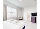 Bright bedroom with king bed, large window, hardwood floors, and ensuite bathroom at 359 Famagusta Dr, Davenport, FL 33896