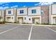 Modern townhomes featuring stone accents, neutral colors, and ample parking space, complemented by vibrant landscaping at 359 Famagusta Dr, Davenport, FL 33896