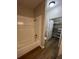 Bright bathroom featuring a tub with tile surround, wood look flooring, and a walk-in closet at 5953 Westgate Dr # 1821, Orlando, FL 32835
