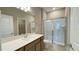 Bathroom with a large mirror, a sink with wooden cabinets, and a glass door shower at 6221 Argent Wood Dr, Winter Garden, FL 34787