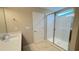 Well-lit bathroom with a modern glass shower, single vanity, and tiled flooring at 6221 Argent Wood Dr, Winter Garden, FL 34787