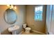 Bathroom with a pedestal sink, toilet, and an oval mirror at 6221 Argent Wood Dr, Winter Garden, FL 34787