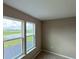 Close-up of bedroom windows allowing natural light with outdoor views of a pond and greenery at 6221 Argent Wood Dr, Winter Garden, FL 34787
