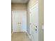Hallway with tiled flooring, showing a standard door and closet with bi-fold doors at 6221 Argent Wood Dr, Winter Garden, FL 34787