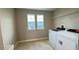 Well-lit laundry room featuring a washer, dryer, tile flooring and two windows at 6221 Argent Wood Dr, Winter Garden, FL 34787