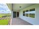 A covered patio with brick pavers, sliding glass doors, and a view of the lush backyard and landscaping at 6221 Argent Wood Dr, Winter Garden, FL 34787
