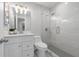 Updated bathroom featuring tiled shower with glass door, modern vanity, and contemporary lighting at 654 Romano Ave, Orlando, FL 32807