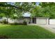 Charming single-story home featuring a manicured lawn, mature trees, and a welcoming front entrance at 654 Romano Ave, Orlando, FL 32807