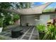 Outdoor patio space with paver blocks, canvas shade, landscaping, and outdoor fireplace at 654 Romano Ave, Orlando, FL 32807