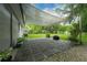 Outdoor patio area with unique pavers, gravel, canvas shade, and lush landscaping at 654 Romano Ave, Orlando, FL 32807