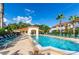 Resort-style community pool with lounge chairs and lush tropical landscaping under a bright blue sunny sky at 962 Park Terrace Cir, Kissimmee, FL 34746