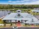 An aerial view shows the community center next to a lake surrounded by trees at 1859 Island Village Way, Kissimmee, FL 34747