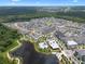 Expansive aerial view of a Primary-planned community featuring lake, pool, and residential and retail areas at 1859 Island Village Way, Kissimmee, FL 34747
