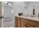 Bathroom with double vanity, wood cabinets, and a view into another room with a small bed at 1859 Island Village Way, Kissimmee, FL 34747