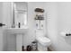 Well-lit powder room featuring pedestal sink and decorative shelves, maximizing both style and functionality at 1859 Island Village Way, Kissimmee, FL 34747