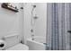 Bright bathroom featuring a tub with a shower and a white tile surround, complimented by stylish fixtures at 1859 Island Village Way, Kissimmee, FL 34747
