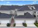 Aerial view showcasing the townhome's gray exterior, white garage doors, and brick-lined walkway at 1859 Island Village Way, Kissimmee, FL 34747
