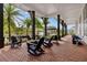 A large covered patio with rocking chairs and outdoor seating overlooks the yard at 1859 Island Village Way, Kissimmee, FL 34747