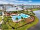 A resort style pool with lounge chairs sits next to a lake and buildings at 1859 Island Village Way, Kissimmee, FL 34747