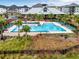 Beautiful swimming pool area featuring palm trees, lounge chairs, and well-maintained landscaping at 1859 Island Village Way, Kissimmee, FL 34747