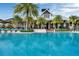 Stunning pool with lounge chairs, palm trees, and a building in the background at 1859 Island Village Way, Kissimmee, FL 34747