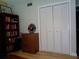 Bedroom featuring closet, bookshelf, wooden floors and a vintage Ohio State accent piece at 1935 Conway Rd # M1, Orlando, FL 32812