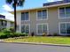 Two-story condo building with gray siding, complemented by green grass and well-maintained landscaping at 1935 Conway Rd # M1, Orlando, FL 32812