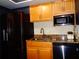 Well-lit kitchen featuring a black fridge, light wood cabinets and granite countertops at 1935 Conway Rd # M1, Orlando, FL 32812