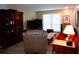 Inviting living room with stylish furnishings, including a red sofa, wooden cabinets, and a comfortable recliner at 1935 Conway Rd # M1, Orlando, FL 32812