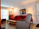 Bright living room features a comfortable red sofa and a plush, neutral-toned recliner, creating an inviting space to unwind at 1935 Conway Rd # M1, Orlando, FL 32812