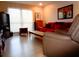 Living room with bright window, red sofa, light floors, artwork, and a comfortable recliner, perfect for relaxing at 1935 Conway Rd # M1, Orlando, FL 32812