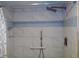 Shower with a handheld shower head, safety bar, blue decorative tile, and built-in shower caddy at 1935 Conway Rd # M1, Orlando, FL 32812