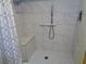 Bright shower featuring white tile, a handheld shower head, built-in seat, and decorative mosaic tile flooring at 1935 Conway Rd # M1, Orlando, FL 32812