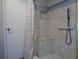 Comfortable shower with safety bar, handheld shower, built-in seat, and mosaic-tiled flooring for added style at 1935 Conway Rd # M1, Orlando, FL 32812